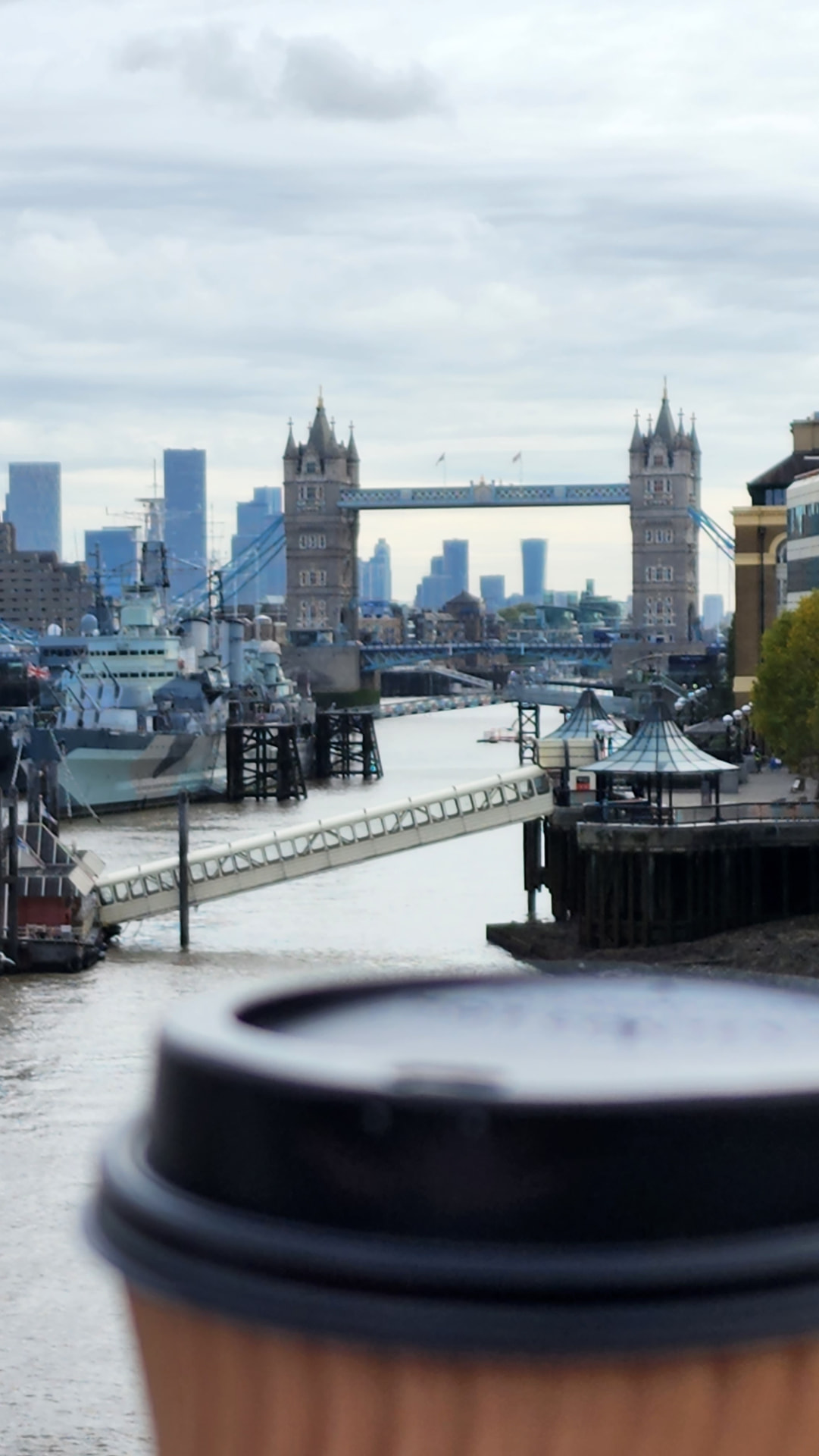 Tower Bridge and the Thames in London, with a coffee cup in the foreground
